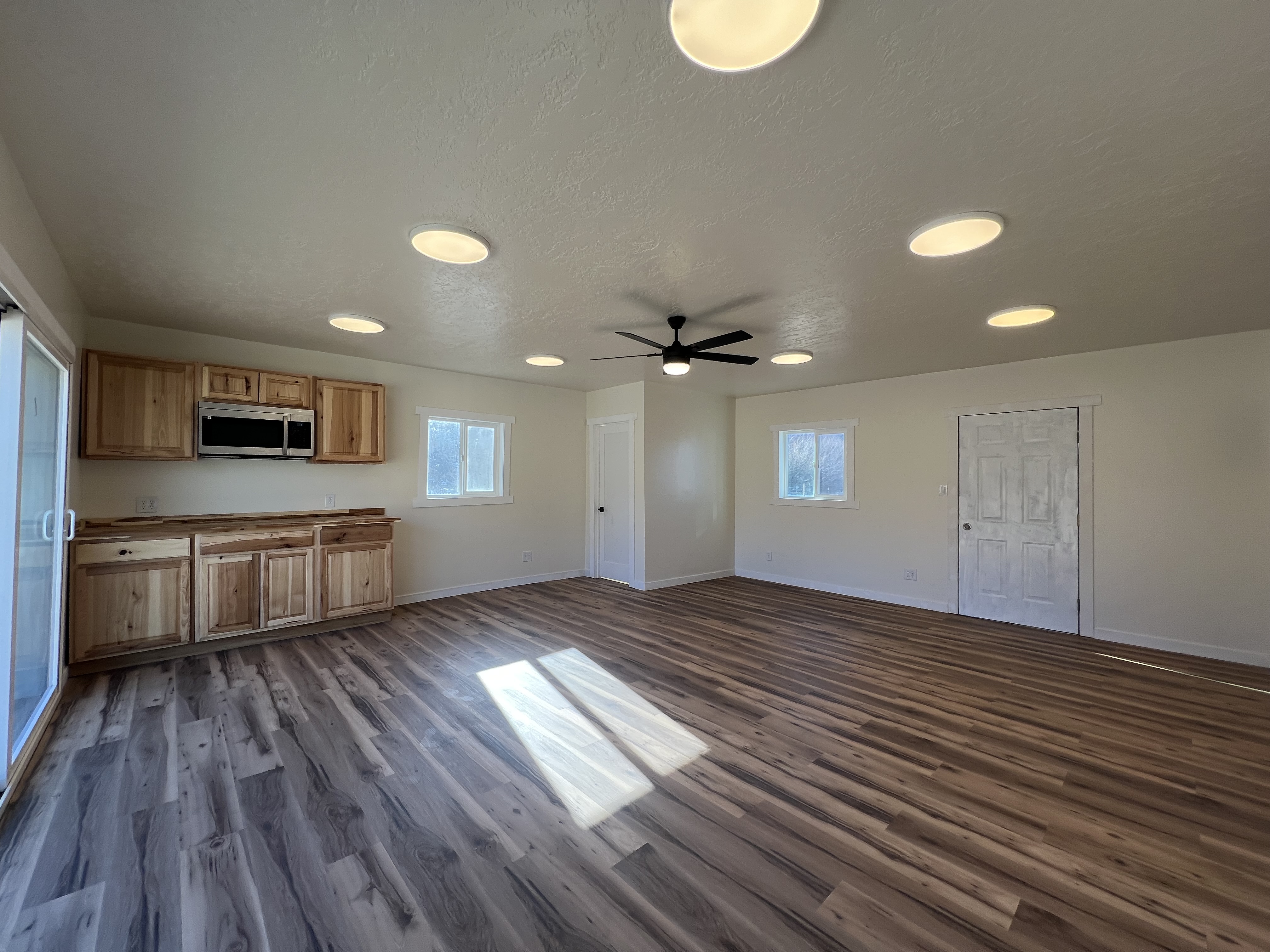 ADU Conversion of existing garage with vinyl flooring, drywall installation, and a custom sliding glass door and a kitchen